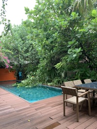 a wooden deck with a pool and chairs